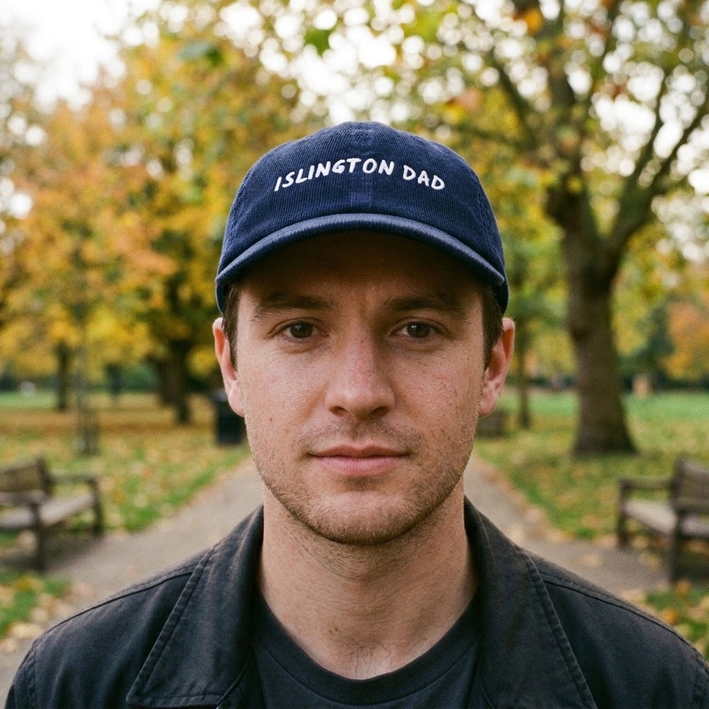 Man wearing the Islington Dad corduroy cap in Oxford Navy on Highbury Fields, Islington, North London