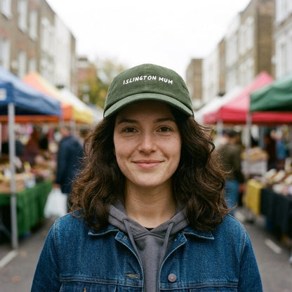 Woman wearing the Islington Mum corduroy cap in Dark Olive at Chapel Market, Islington, North London