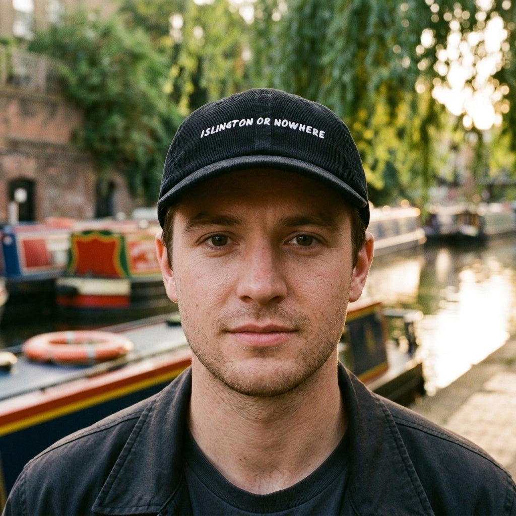 Man wearing the Islington or Nowhere corduroy cap in Black by the Regent's Canal, Islington