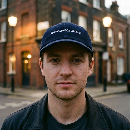 Man wearing the North London or Bust corduroy cap in Oxford Navy in Highbury, Islington, North London