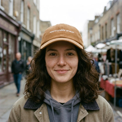 Woman wearing the North London or Bust corduroy cap in Camel in Camden Passage, Islington, North London
