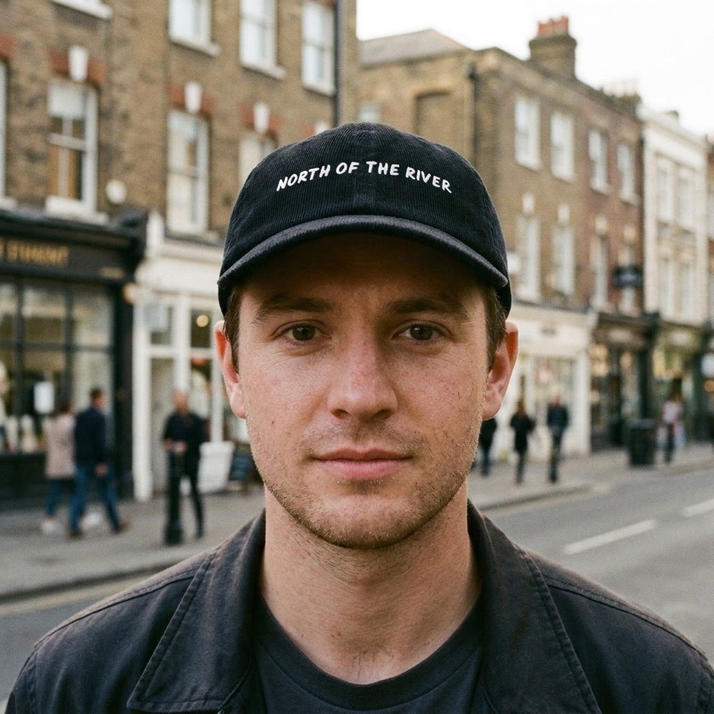 Man wearing the North of the River corduroy cap in Black at Angel, Islington, North London